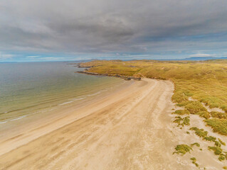 Aerial drone view on Silver strand beach in county Mayo, Ireland. Long sandy beach with beautiful views and peaceful atmosphere. Blue cloudy sky.