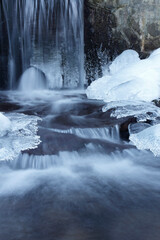 Mountain stream in winter. Ice on the stream.