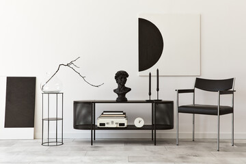 Interior design of modern living room with black stylish commode, chair, mock up art paintings, lamp, book, candlestick, decorations and elegant accessories in home decor. Template.