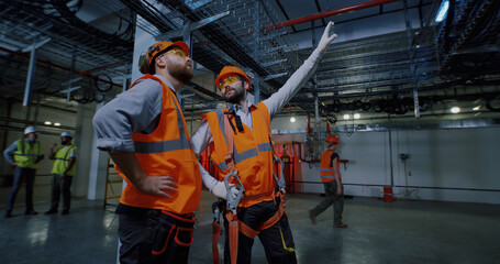 Male workers walking and talking on factory