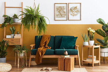 Stylish scandinavian interior of living room with design green velvet sofa, gold pouf, wooden furniture, plants, carpet, cube and mock up poster frames. Template.