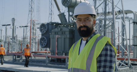 Mature foreman crossing arms on power plant