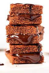 Tasty homemade chocolate cake with chocolate filling on a white background close-up. Stack of chocolate brownies. Sweet food, homemade cakes. 