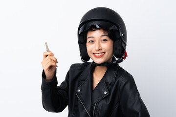 Young Asian girl with a motorcycle helmet and a key over isolated white background