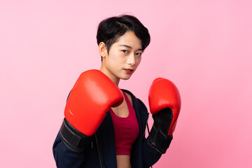 Young sport Asian woman over isolated pink background with boxing gloves