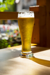 Beer in a glass glass on a wooden table in a summer