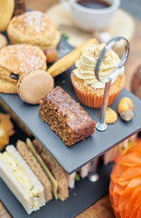 A beautiful gourmet selection of english afternoon tea cakes and scones served with organic...