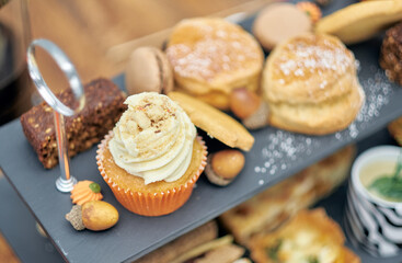 A beautiful gourmet selection of english afternoon tea cakes and scones served with organic...