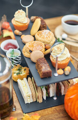 A beautiful gourmet selection of english afternoon tea cakes and scones served with organic cupcakes, tea and coffee, strawberry jam and clotted cream. traditional british food.