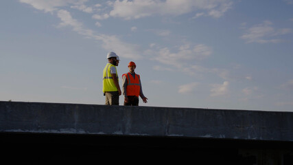 Contractors talking on unfinished bridge