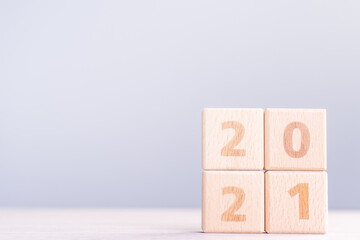 2021 New Year abstract design concept - Number wood block cubes isolated on wooden table and light...