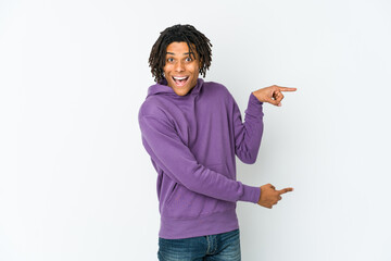 Young african american rasta man excited pointing with forefingers away.