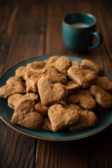 Homemade wholegrain cookies with oatmeal, raisin, nuts, seeds and milk on brown rustic wooden background. Healthy eating concept