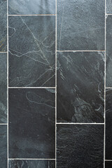 Tiles of dark grey stone with white seams