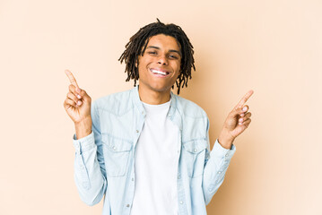 Young african american rasta man pointing to different copy spaces, choosing one of them, showing with finger.