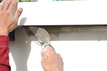 Construction worker, wall plastering trowel repair cracks
