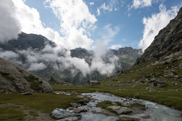 landscape with small house and clouds in the mountains