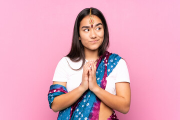 Young Indian woman with sari over isolated background scheming something