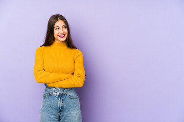 Young caucasian woman isolated on purple background smiling confident with crossed arms.