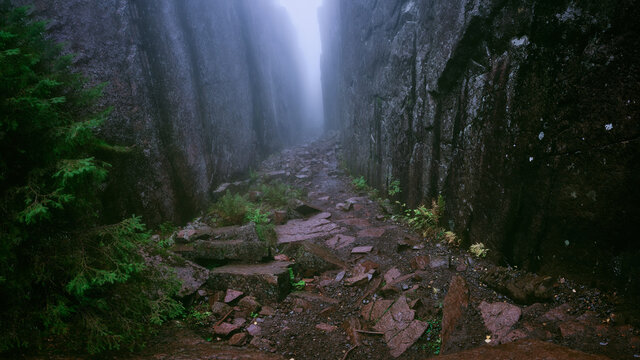 High cliffs on both sides at once leading away in foggy weather