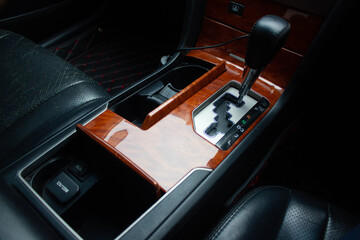Naklejka premium automatic transmission shift selector in the car interior. Closeup a manual shift of modern car gear sifter.
