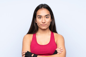 Young Indian sport woman isolated on blue background with arms crossed