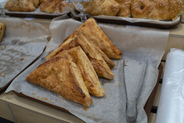 Samsa. Triangular shaped meat patties on a store counter.