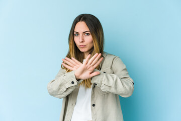 Young caucasian woman isolated on blue background doing a denial gesture