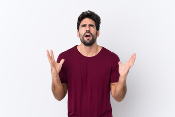 Young handsome man with beard over isolated white background frustrated by a bad situation
