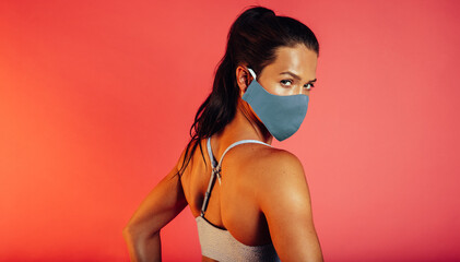 Fitness woman in a face mask glancing back