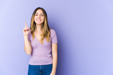 Young caucasian woman isolated on purple background showing number one with finger.