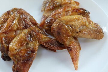 close-up grilled chicken wings in white plate
