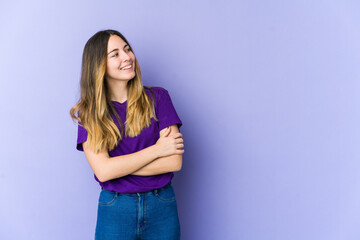 Young caucasian woman isolated on purple background smiling confident with crossed arms.