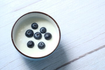 close up of fresh yogurt with blue berry in a bowl 