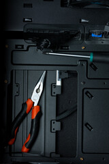 Tools inside Pc case, representing pc building and service. Black background with place for text.