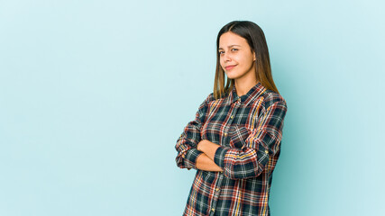 Young woman isolated on blue background suspicious, uncertain, examining you.