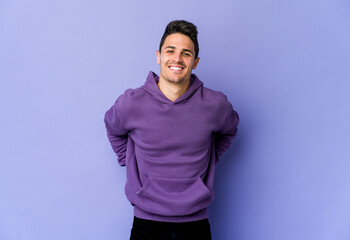 Obraz premium Young caucasian man isolated on purple background happy, smiling and cheerful.