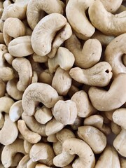 Nuts Cashews are scattered as a background on a table.