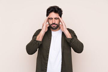 Young handsome man with beard over isolated background with headache