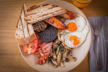Full Scottish breakfast containing tomato, black pudding, haggis, sausages, bacon, mushrooms, fried...