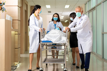 Team medical doctor pushing stretcher gurney bed corridor with female patient in hospital. Health...