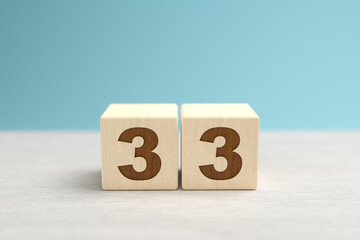 Wooden toy blocks forming the number 33.