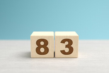 Wooden toy blocks forming the number 83.