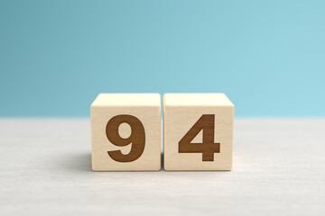 Wooden toy blocks forming the number 94.