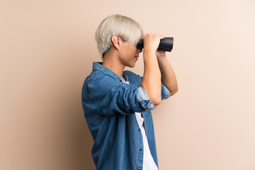 Obraz premium Young asian man over isolated background with black binoculars