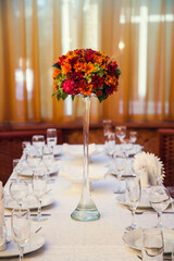 Autumn bouquet of flowers decorates the festive table in the restaurant