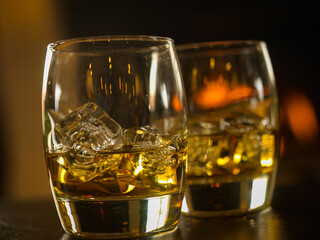 scotch whisky glassees with decanter and fire in background