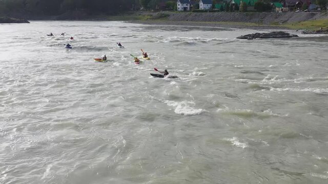Group of people sails in the inflatable boat on the mountain river. Rafting sports