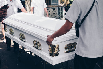 Close up of pallbearers guiding the casket out during funeral procession. Selective focus - obrazy, fototapety, plakaty