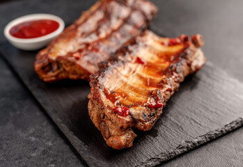 grilled pork ribs with spices on a stone background